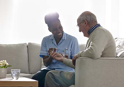 Caregiver sitting with resident | National Lutheran Communities & Services