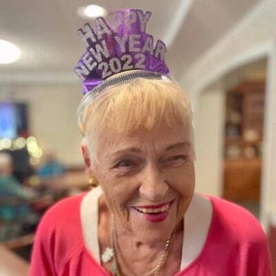 Resident smiling with a New Year’s Eve hat | National Lutheran Communities & Services